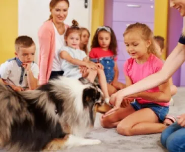 Children sitting on the floor petting a dog