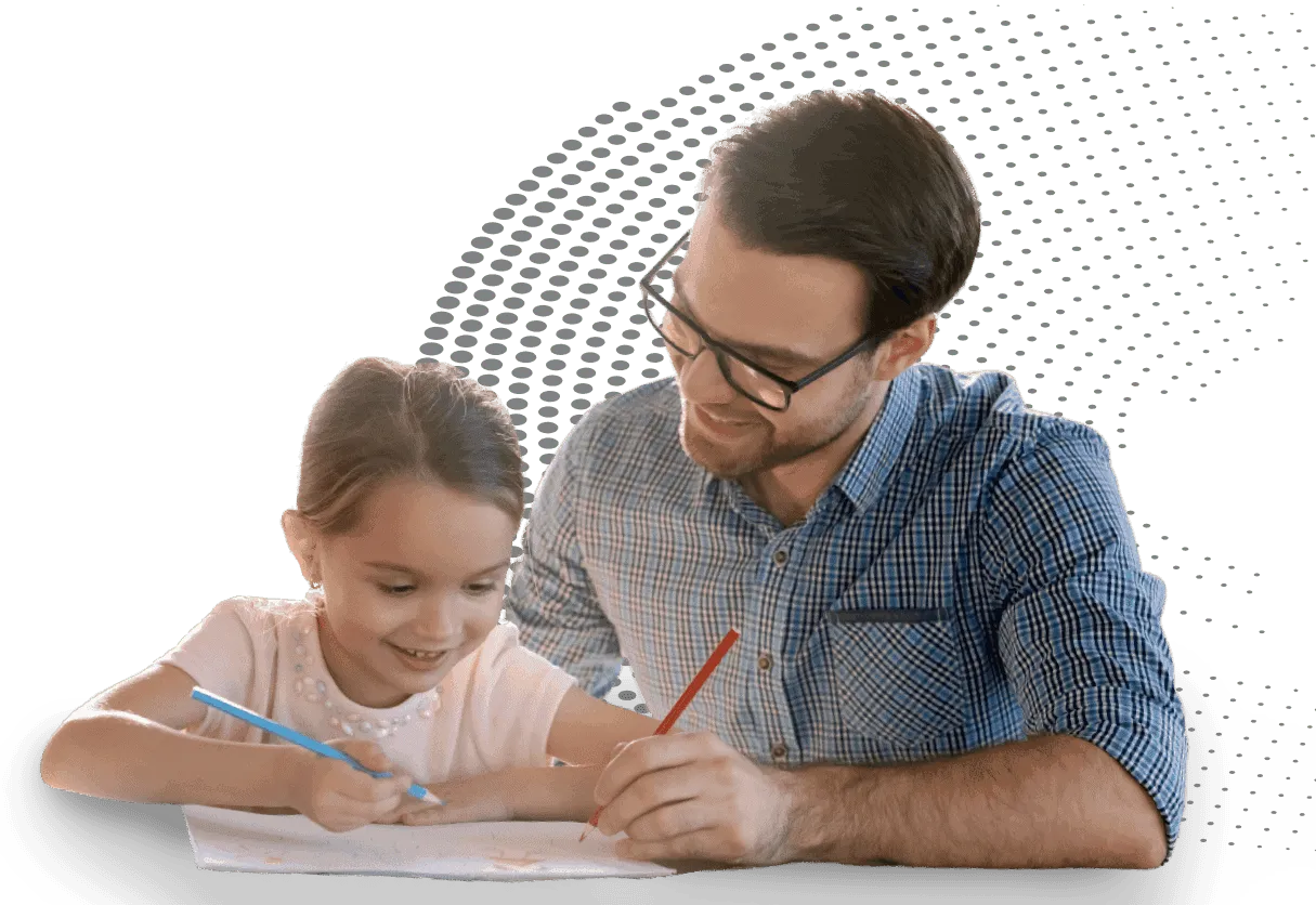 A counselor smiling as a young girl draws at a table