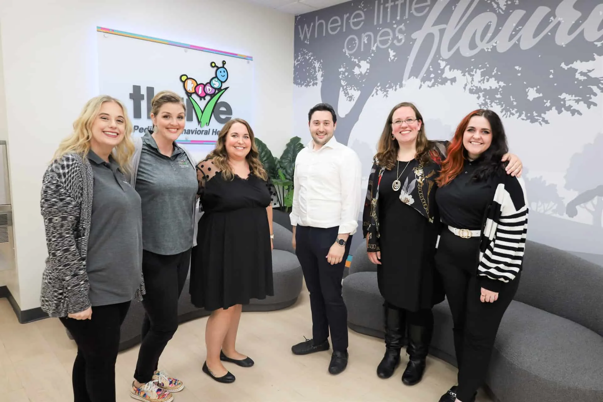 Six people standing together in the Kids Thrive lobby at an open house
